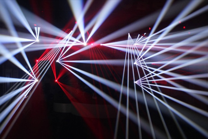 White beams fanning from moving heads