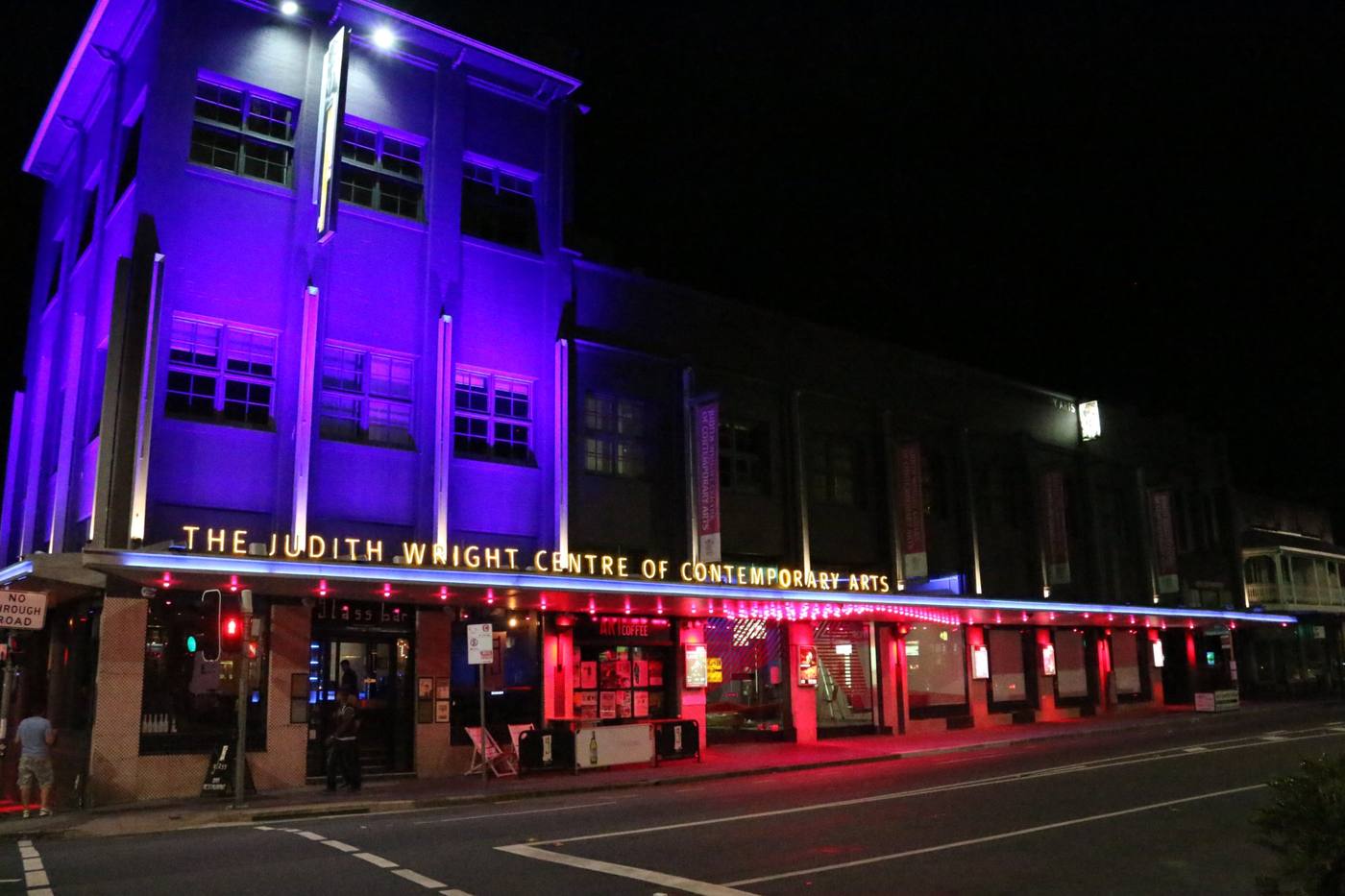 Judith Wright Centre facade washed in blue and red at night