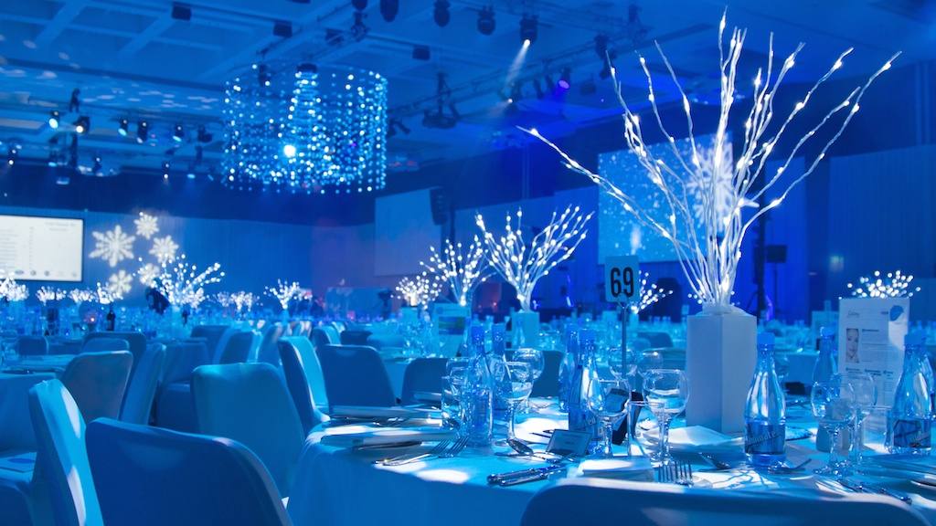 Winter gala dinner tables lit in cold blue with white branch centrepieces